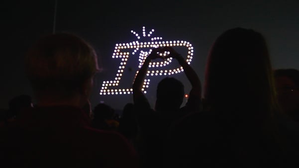 Purdue P with a student giving a heart to it. College drone show.