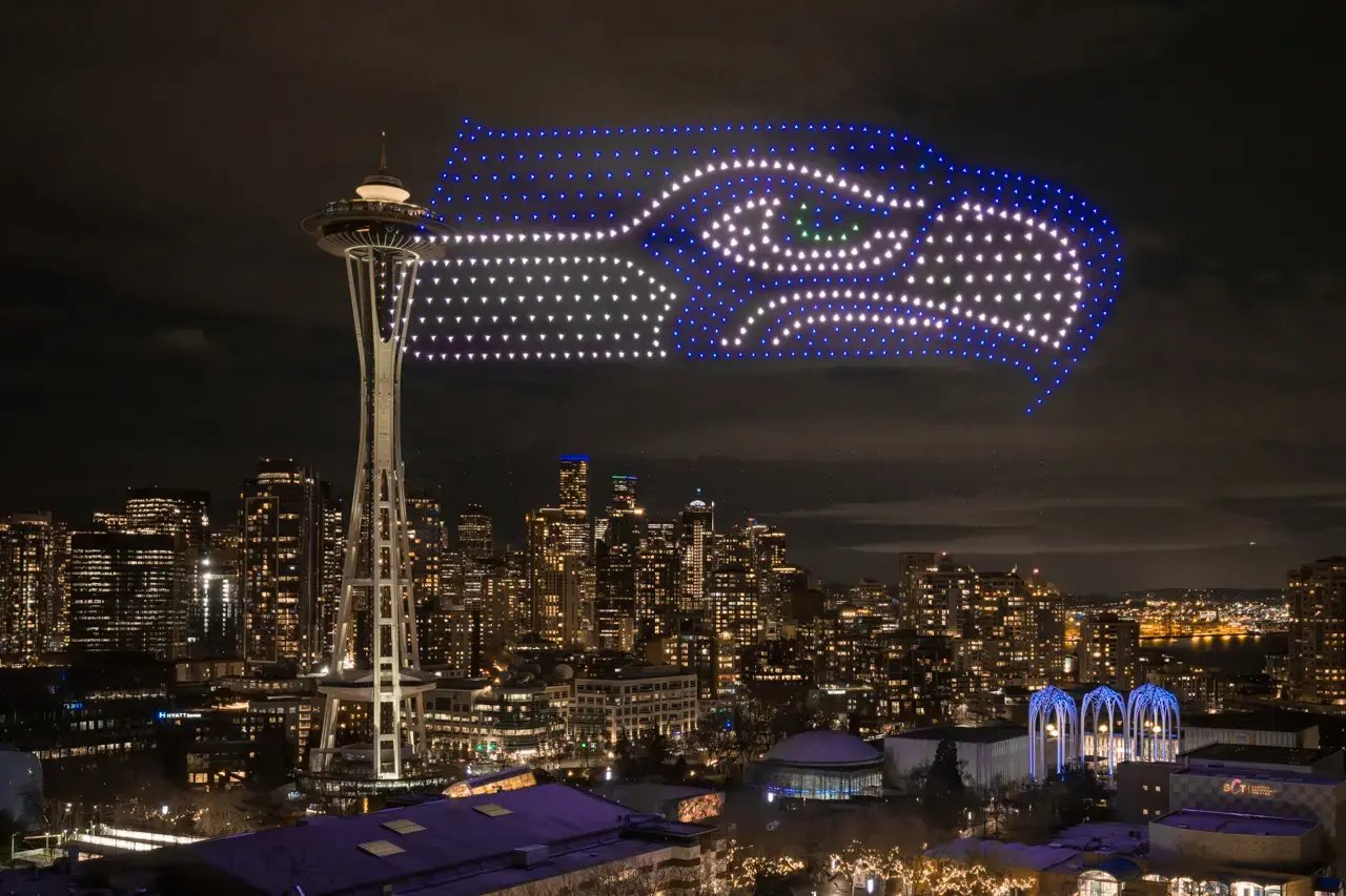 an image of the seattle sehawks logo made with drones next to the space needle in seattle washington