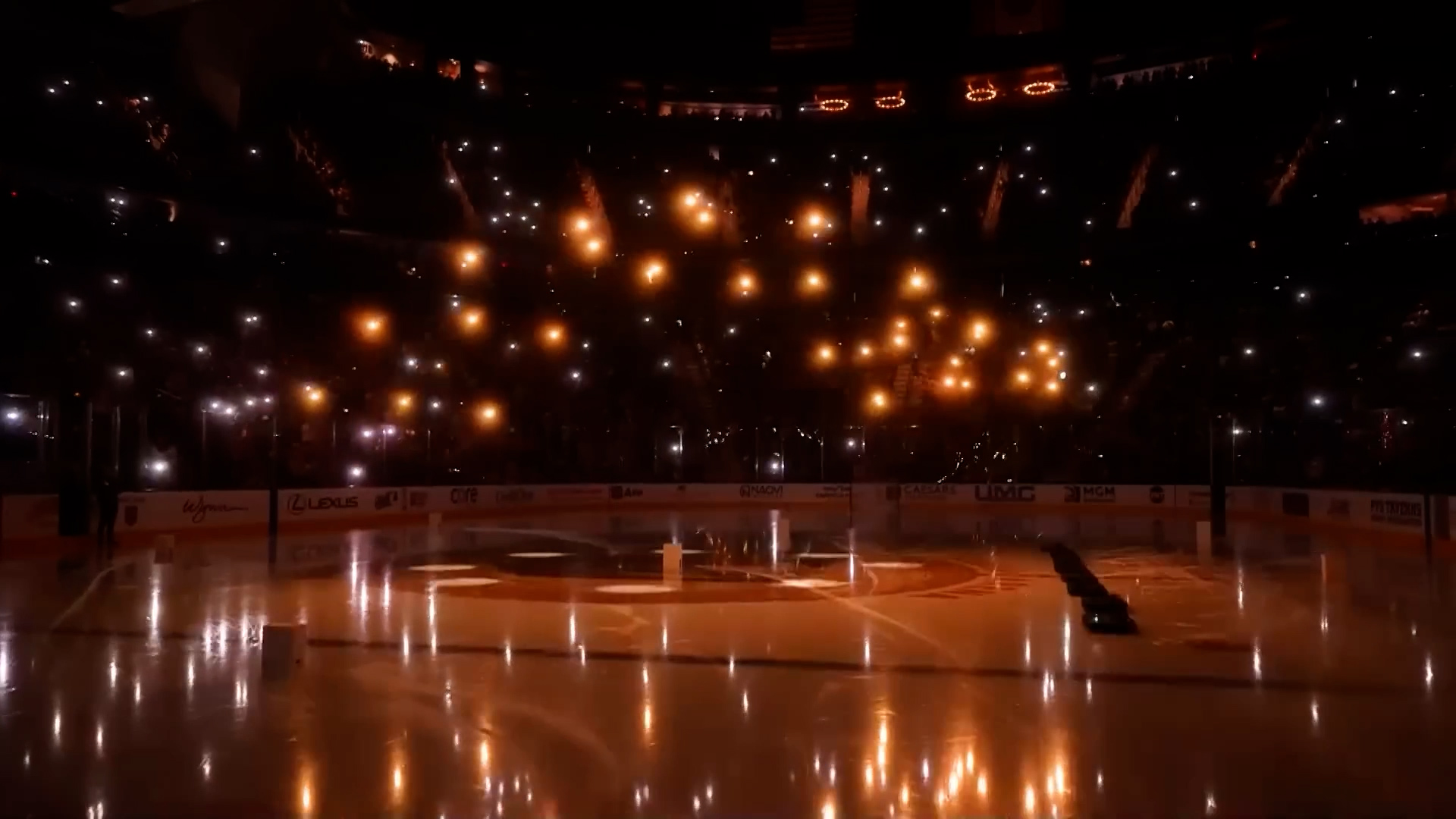 Indoor drone light show over the ice at an NHL arena with the crowd holding lights