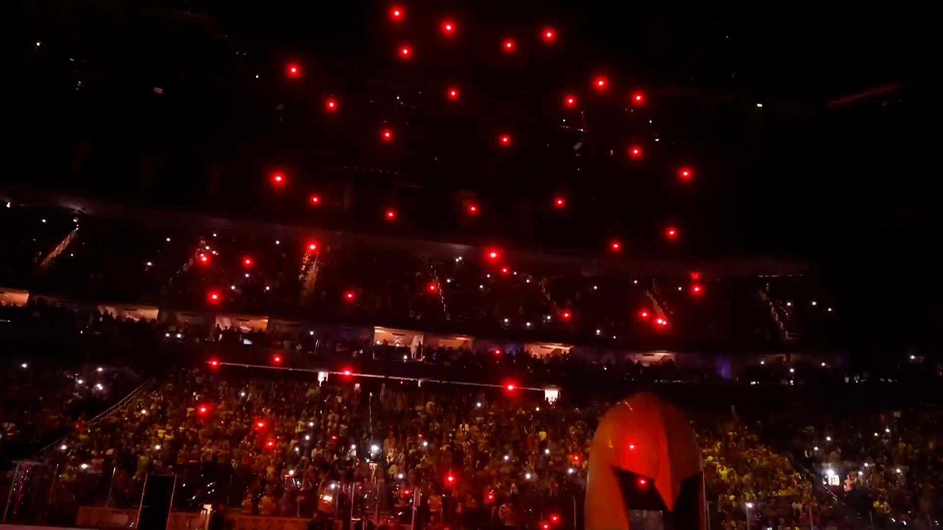Drone formation glowing red above a packed NHL arena crowd
