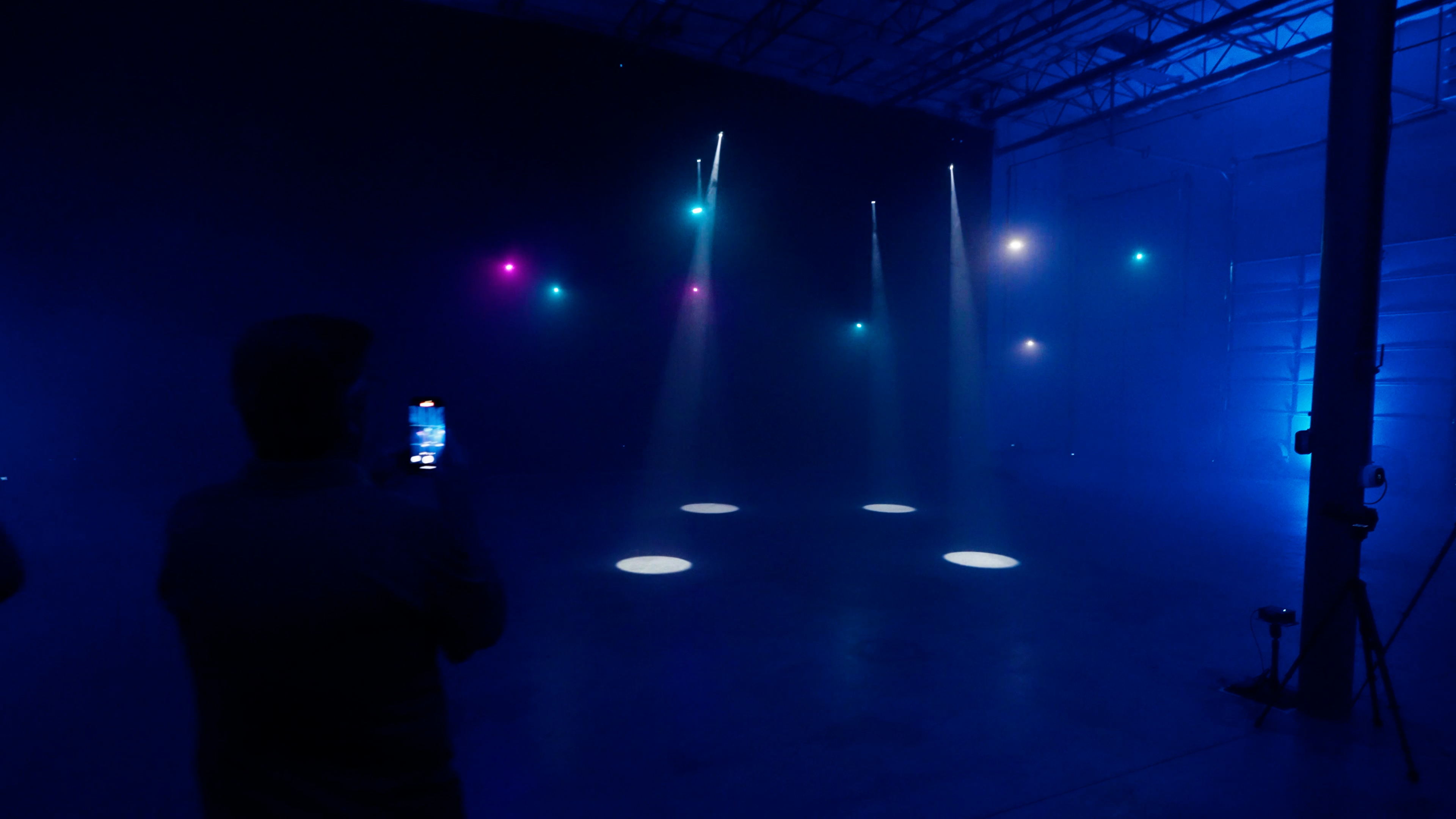 Micro drones with flying searchlight beams during an indoor demo