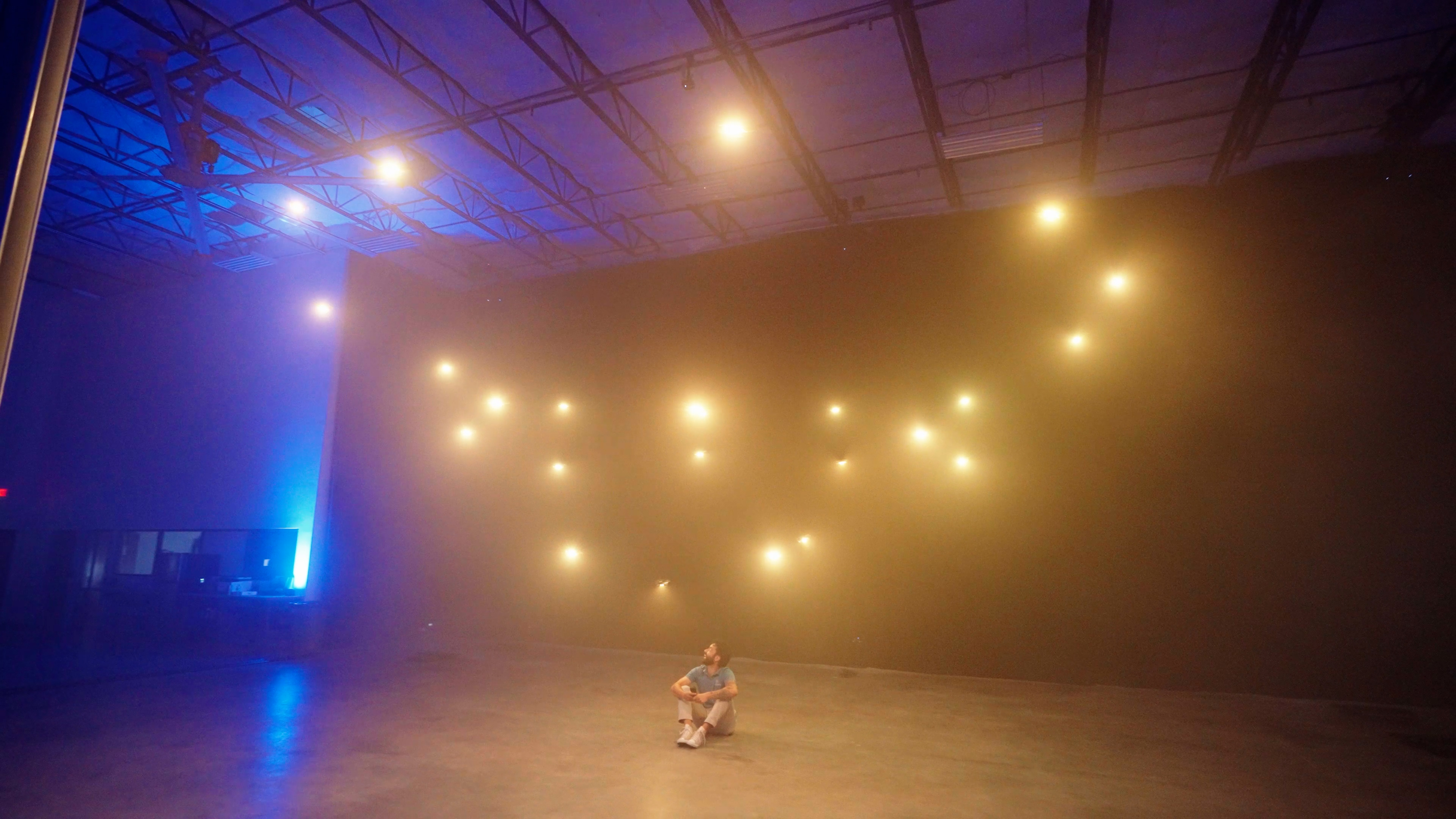 Drones glowing warm above a seated audience indoors