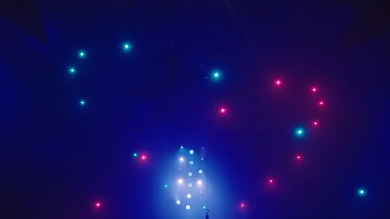 Twin heart formations in cyan and magenta drones over a dark room