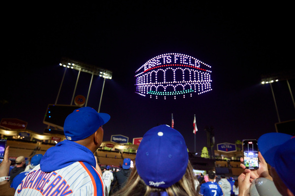 a drone show showing a image of a stadium in New York with fans watching the performance